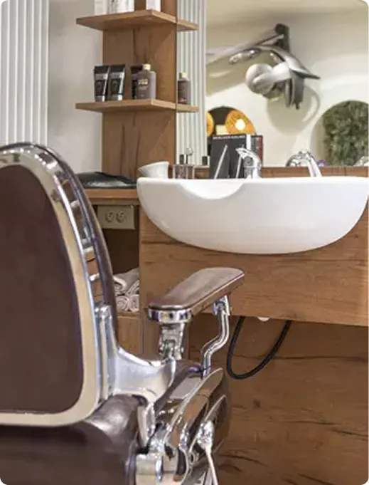 Chaises de salon de coiffure moderne avec lavabo et accessoires stylisés.